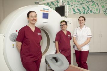 radiographers next to CT scanner